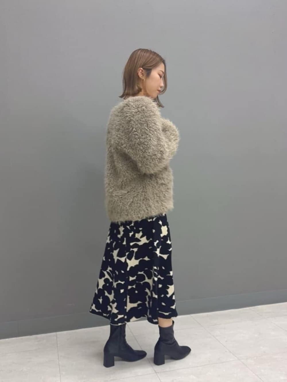 ブラウン系のブルゾン、ブラック系のワンピースを着用したレディースの冬コーディネートの2枚目の写真