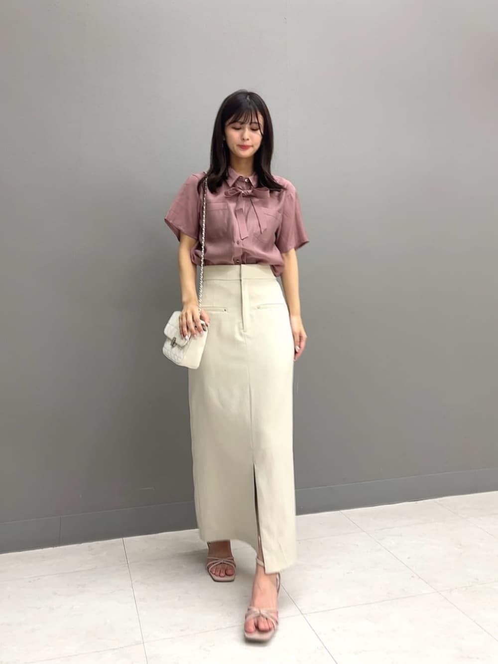 ホワイト系のショルダーバッグ、ピンク系のシャツ/ブラウス、ベージュ系のスカートを着用したレディースの夏コーディネートの2枚目の写真