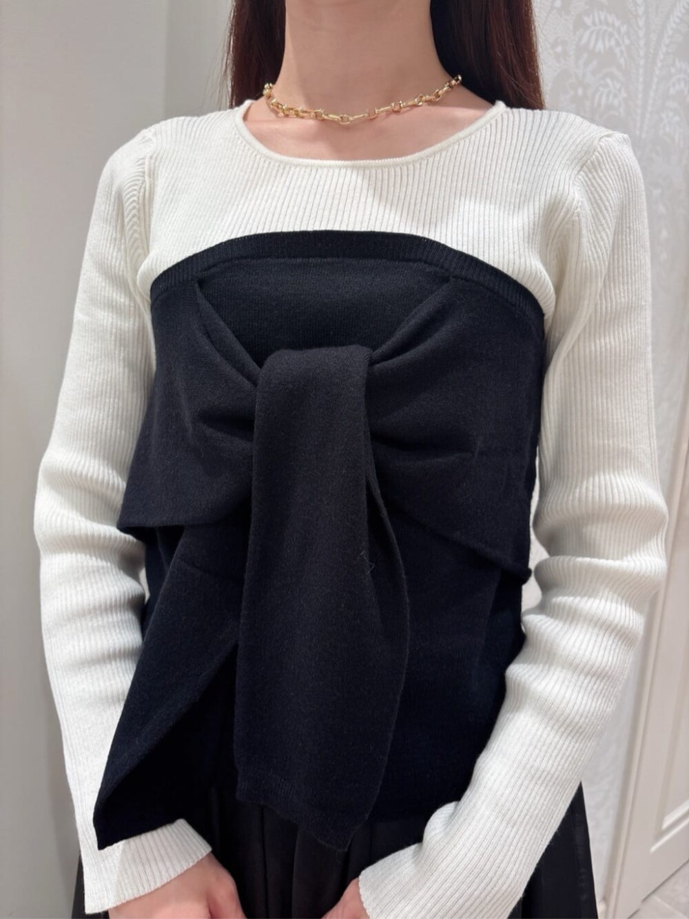 ブラック系のニット/セーター、ブラック系のスカート、パープル系のトートバッグを着用したレディースの秋コーディネートの3枚目の写真