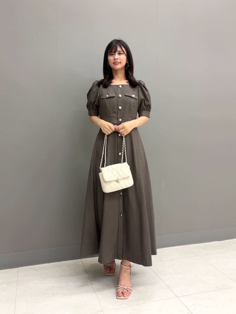 ホワイト系のショルダーバッグ、ブラウン系のワンピースを着用したレディースの夏コーディネートの2枚目の写真