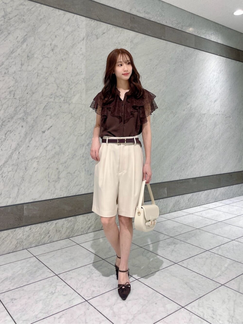 ホワイト系のショルダーバッグ、ブラウン系のシャツ/ブラウス、ホワイト系のその他パンツを着用したレディースの春コーディネートの2枚目の写真