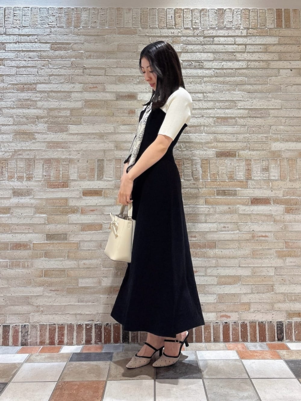 ブラック系のワンピースを着用したレディースの春コーディネートの2枚目の写真