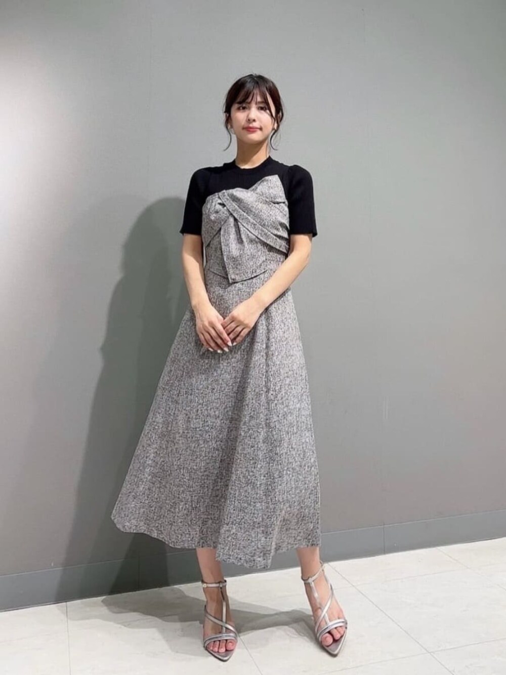 シルバー系のパンプス、ブラウン系のワンピースを着用したレディースの春コーディネートの2枚目の写真