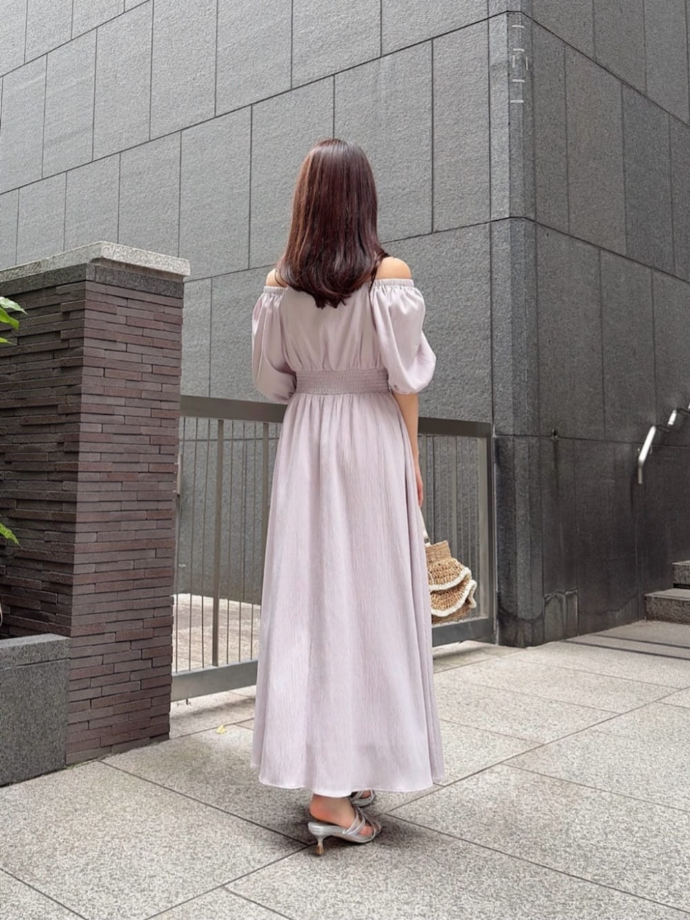 シルバー系のパンプス、ベージュ系のショルダーバッグ、ピンク系のワンピースを着用したレディースの春コーディネートの4枚目の写真