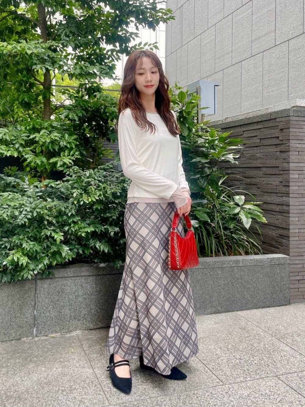 ブラック系のパンプス、ホワイト系のTシャツ/カットソー、ベージュ系のスカートを着用したレディースの秋コーディネートの3枚目の写真