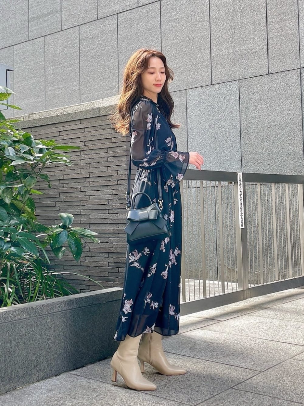 ブラック系のワンピース、ブラック系のショルダーバッグを着用したレディースの冬コーディネートの2枚目の写真