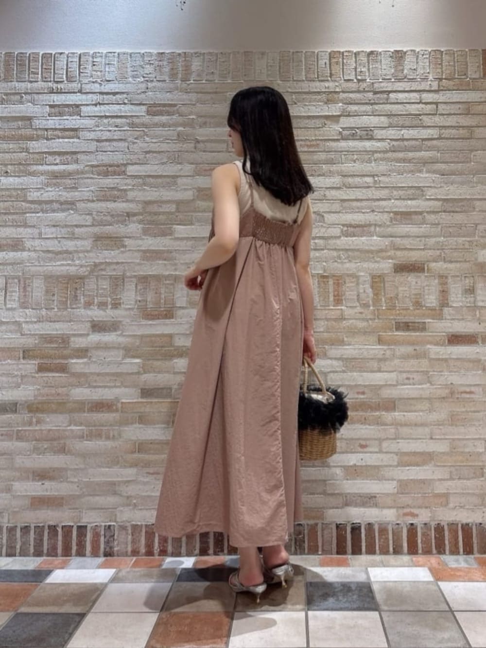 シルバー系のパンプス、ブラック系のショルダーバッグ、ピンク系のワンピースを着用したレディースの夏コーディネートの2枚目の写真