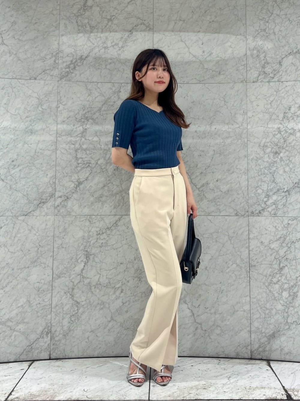 シルバー系のパンプス、ブラック系のショルダーバッグ、グリーン系のニット/セーターを着用したレディースの夏コーディネートの3枚目の写真