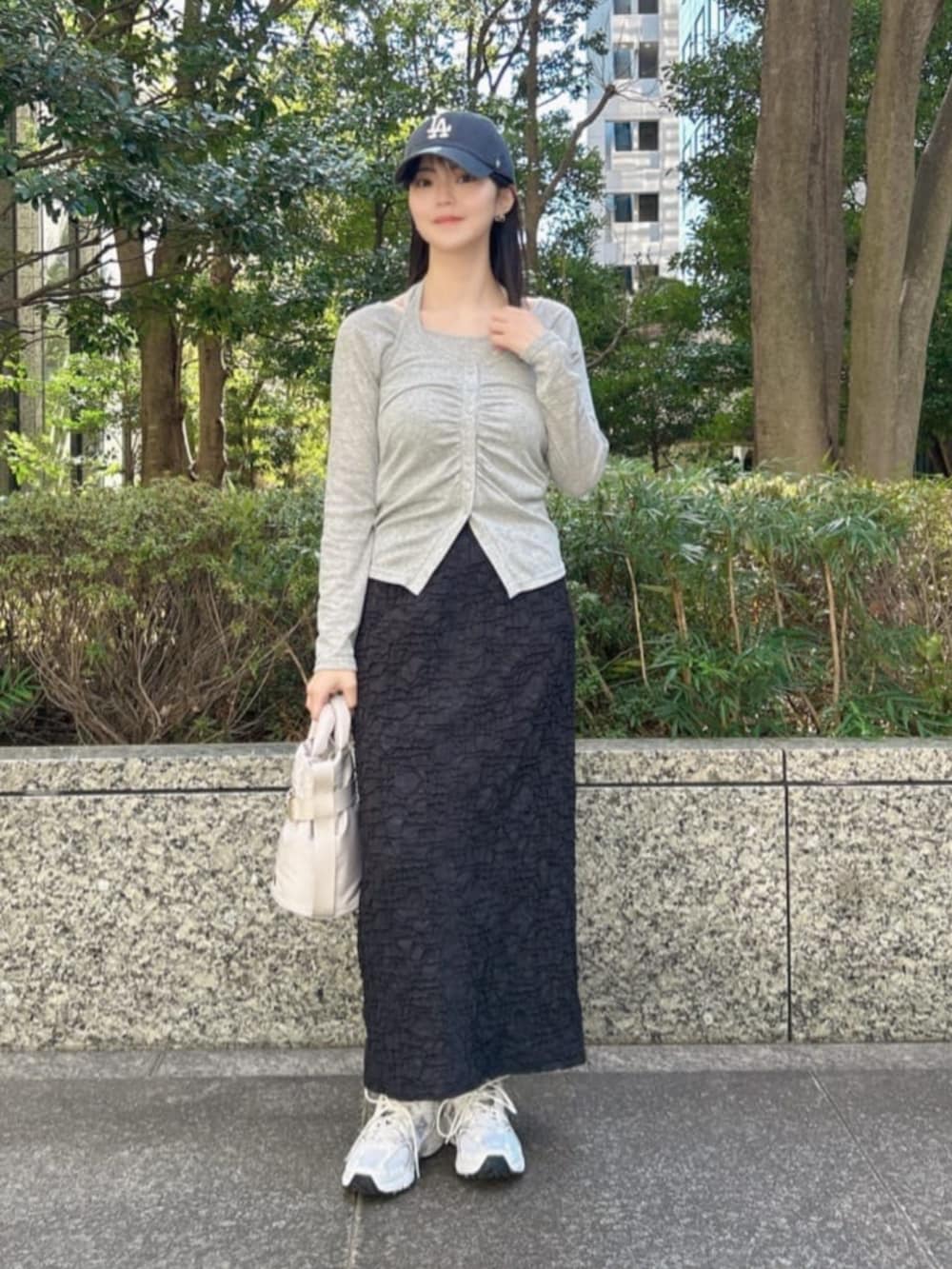 グレー系のTシャツ/カットソー、ブラック系のスカートを着用したレディースの春コーディネートの2枚目の写真