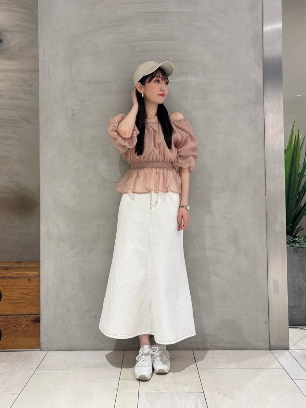 ベージュ系のシャツ/ブラウス、ホワイト系のスカート、ベージュ系のキャップを着用したレディースの春コーディネートの2枚目の写真