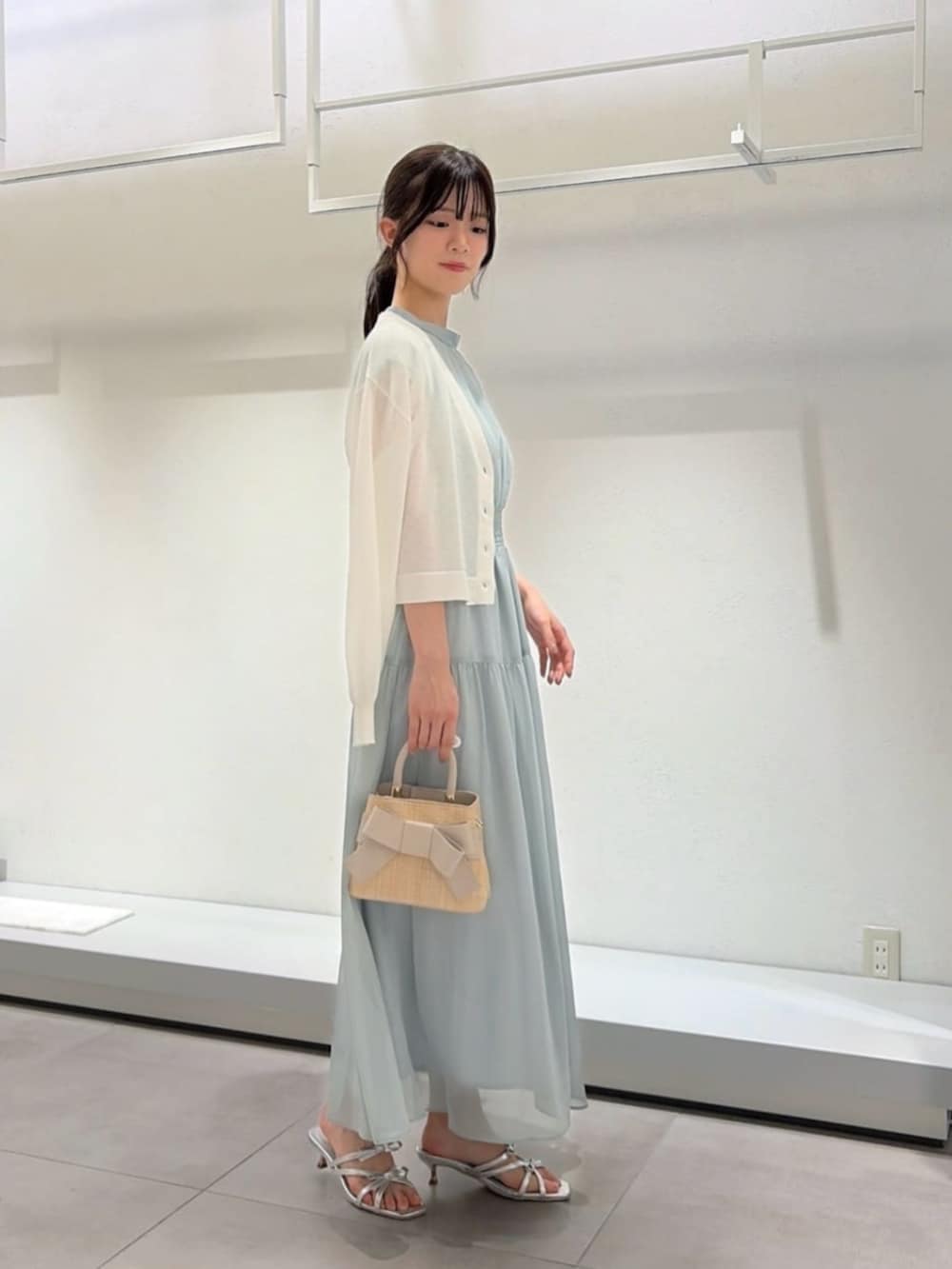 シルバー系のパンプス、ホワイト系のショルダーバッグ、ホワイト系のカーディガン/ボレロを着用したレディースの夏コーディネートの3枚目の写真