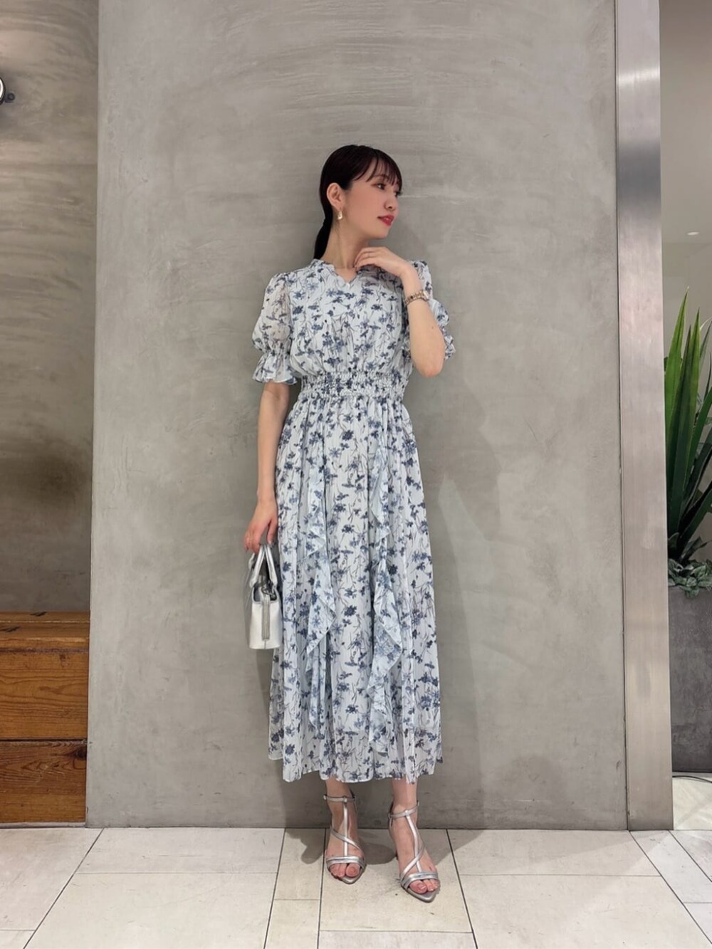 シルバー系のパンプス、ブルー系のワンピースを着用したレディースの春コーディネートの2枚目の写真