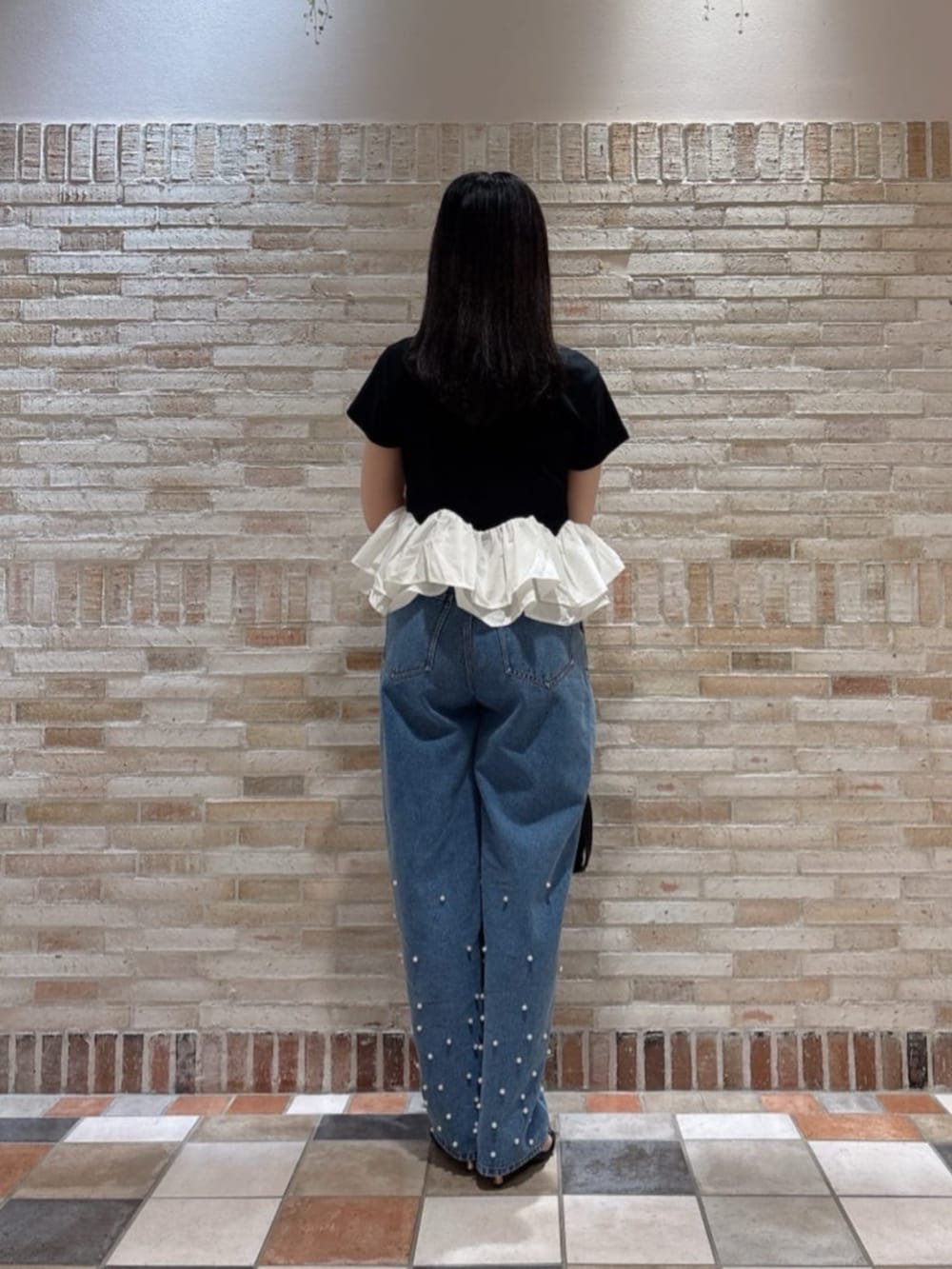 ブラック系のパンプス、ブラック系のTシャツ/カットソー、ブルー系のデニムパンツを着用したレディースの夏コーディネートの3枚目の写真