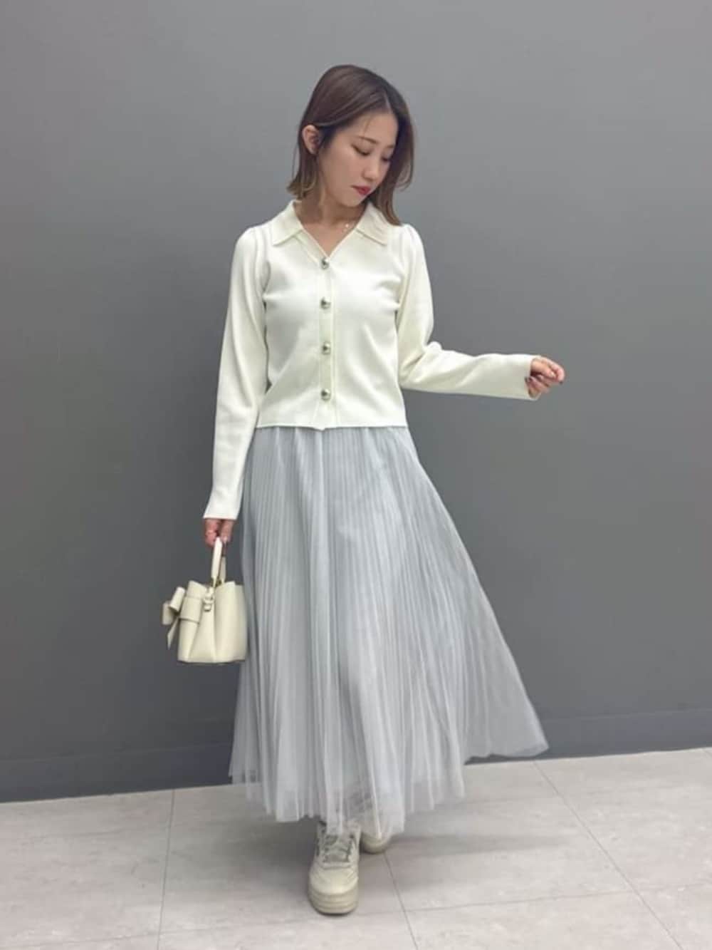 ホワイト系のニット/セーター、グレー系のスカート、ホワイト系のショルダーバッグを着用したレディースの冬コーディネートの2枚目の写真