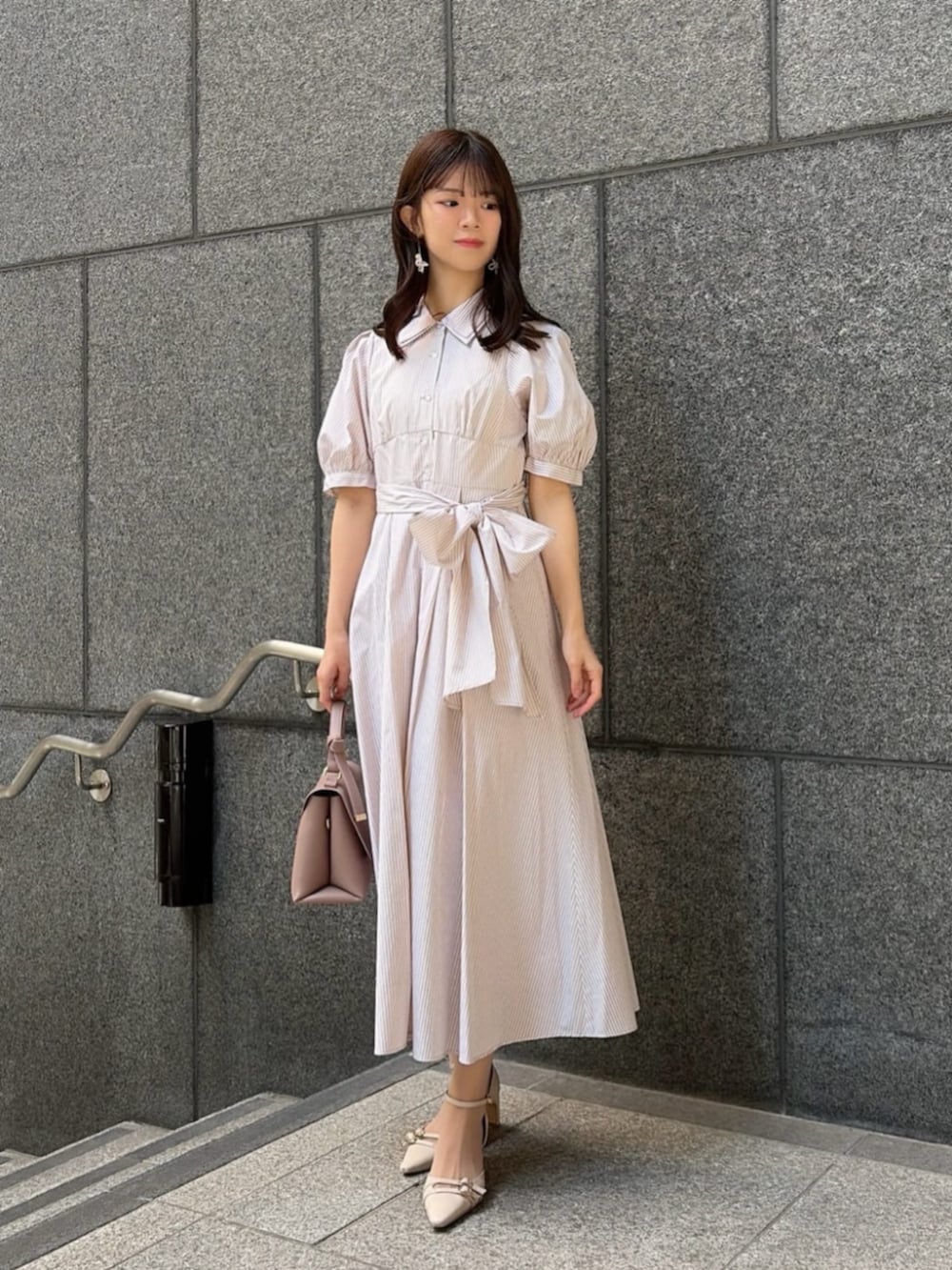 ベージュ系のパンプス、ベージュ系のワンピース、ブラウン系のトートバッグを着用したレディースの春コーディネートの2枚目の写真