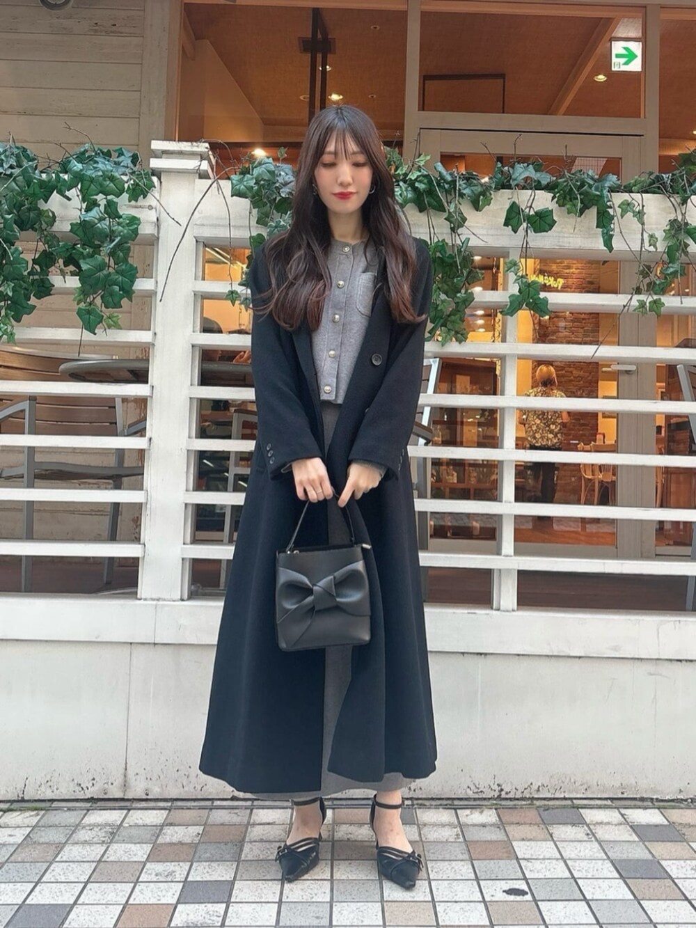 ブラック系のパンプス、ブラック系のショルダーバッグ、グレー系のワンピースを着用したレディースの秋コーディネートの3枚目の写真