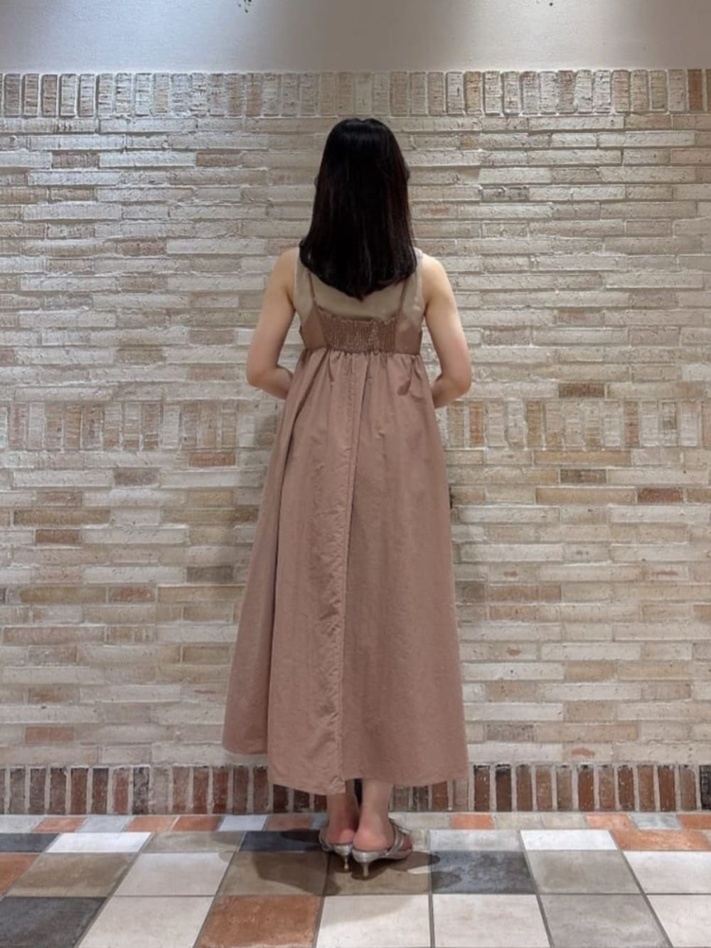 シルバー系のパンプス、ブラック系のショルダーバッグ、ピンク系のワンピースを着用したレディースの夏コーディネートの3枚目の写真