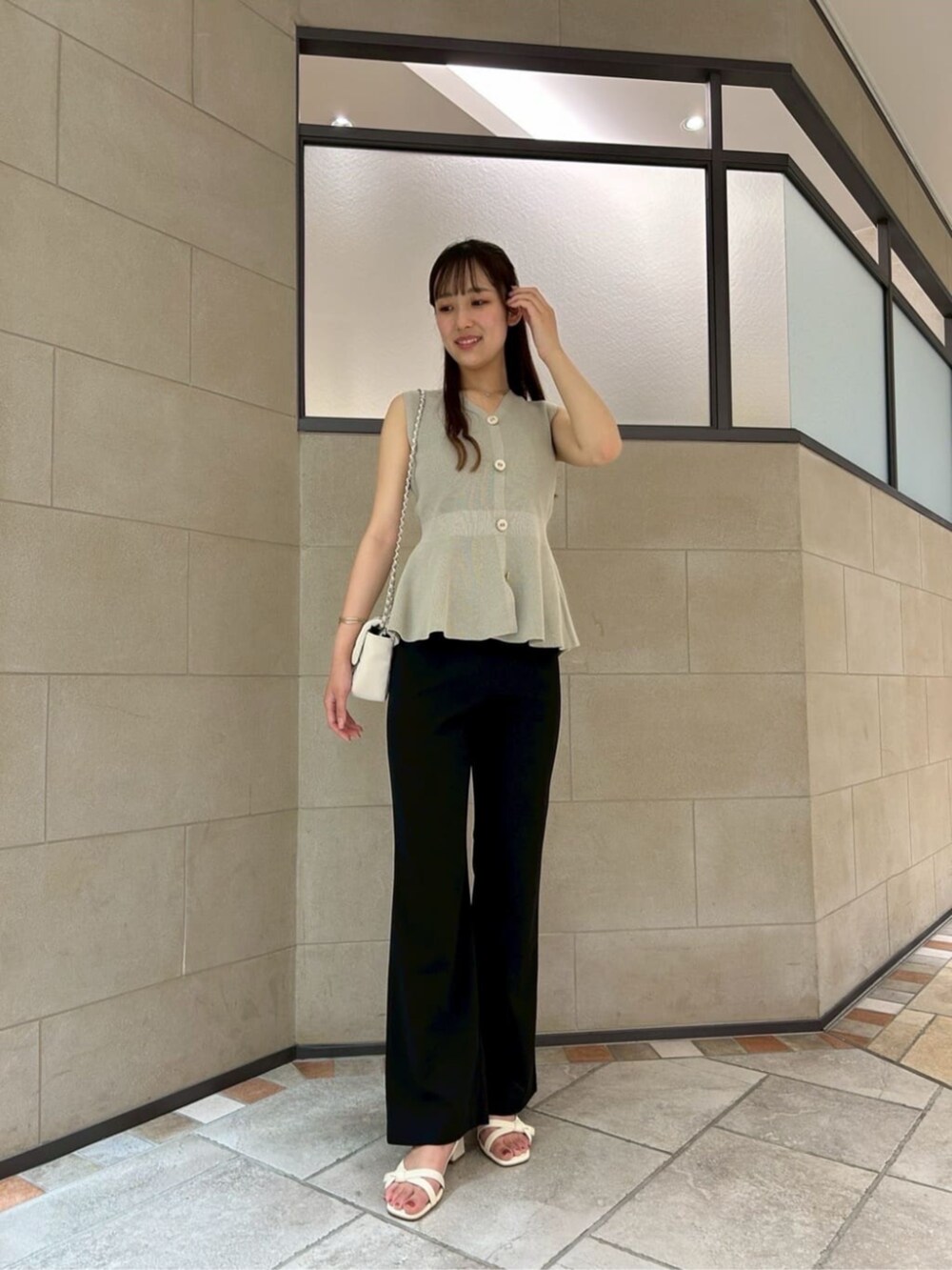 ホワイト系のショルダーバッグ、グリーン系のニット/セーター、ブラック系のその他パンツを着用したレディースの夏コーディネートの3枚目の写真