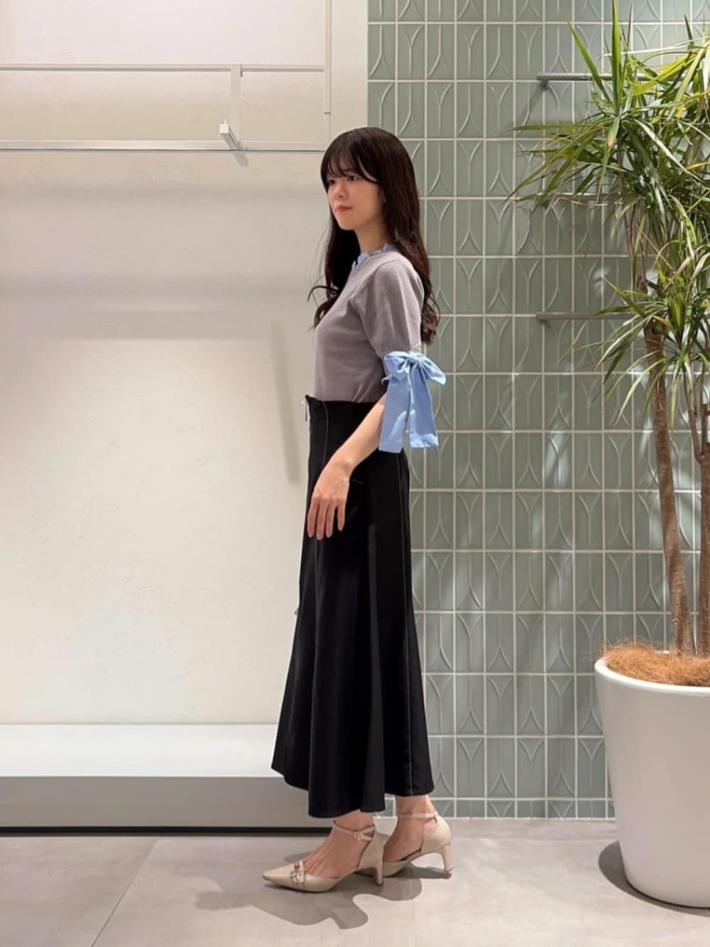 ベージュ系のパンプス、グレー系のニット/セーター、ブラック系のスカートを着用したレディースの秋コーディネートの3枚目の写真