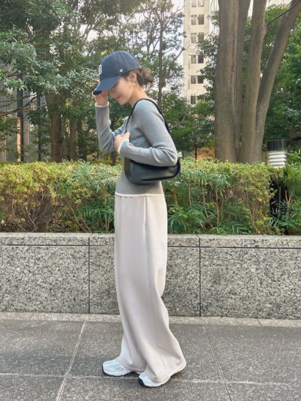 ブラック系のハンドバッグ、グレー系のスウェットパンツ、グレー系のニット/セーターを着用したレディースの冬コーディネートの2枚目の写真