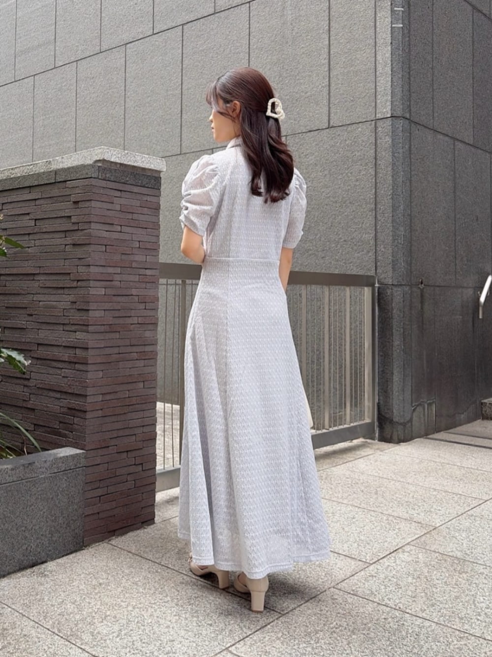ベージュ系のパンプス、グレー系のワンピース、ホワイト系のショルダーバッグを着用したレディースの春コーディネートの3枚目の写真