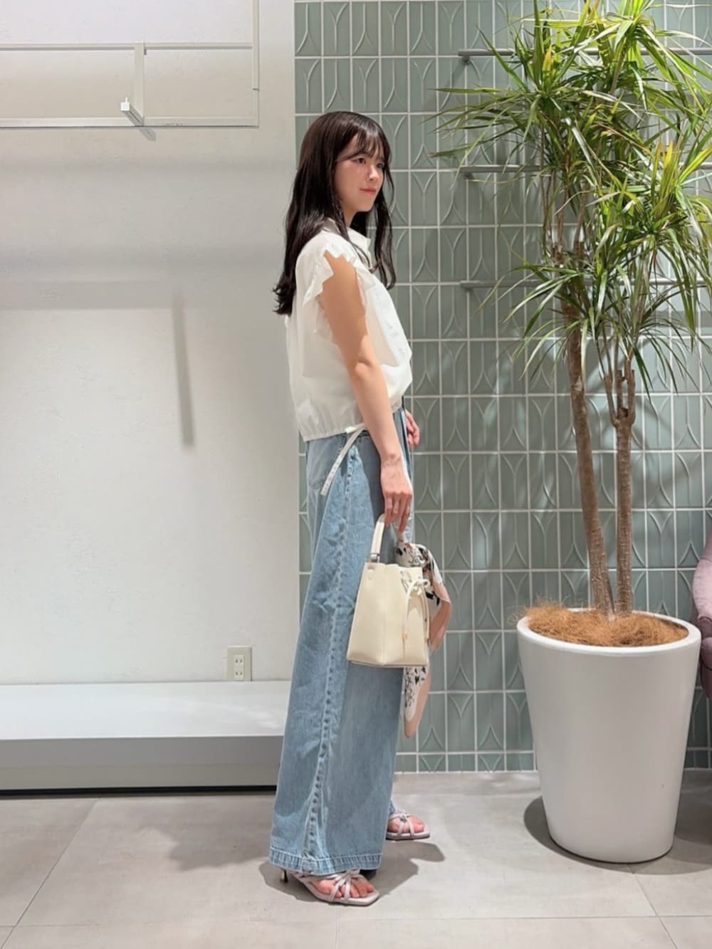 ホワイト系のショルダーバッグ、パープル系のパンプス、ホワイト系のシャツ/ブラウスを着用したレディースの夏コーディネートの2枚目の写真