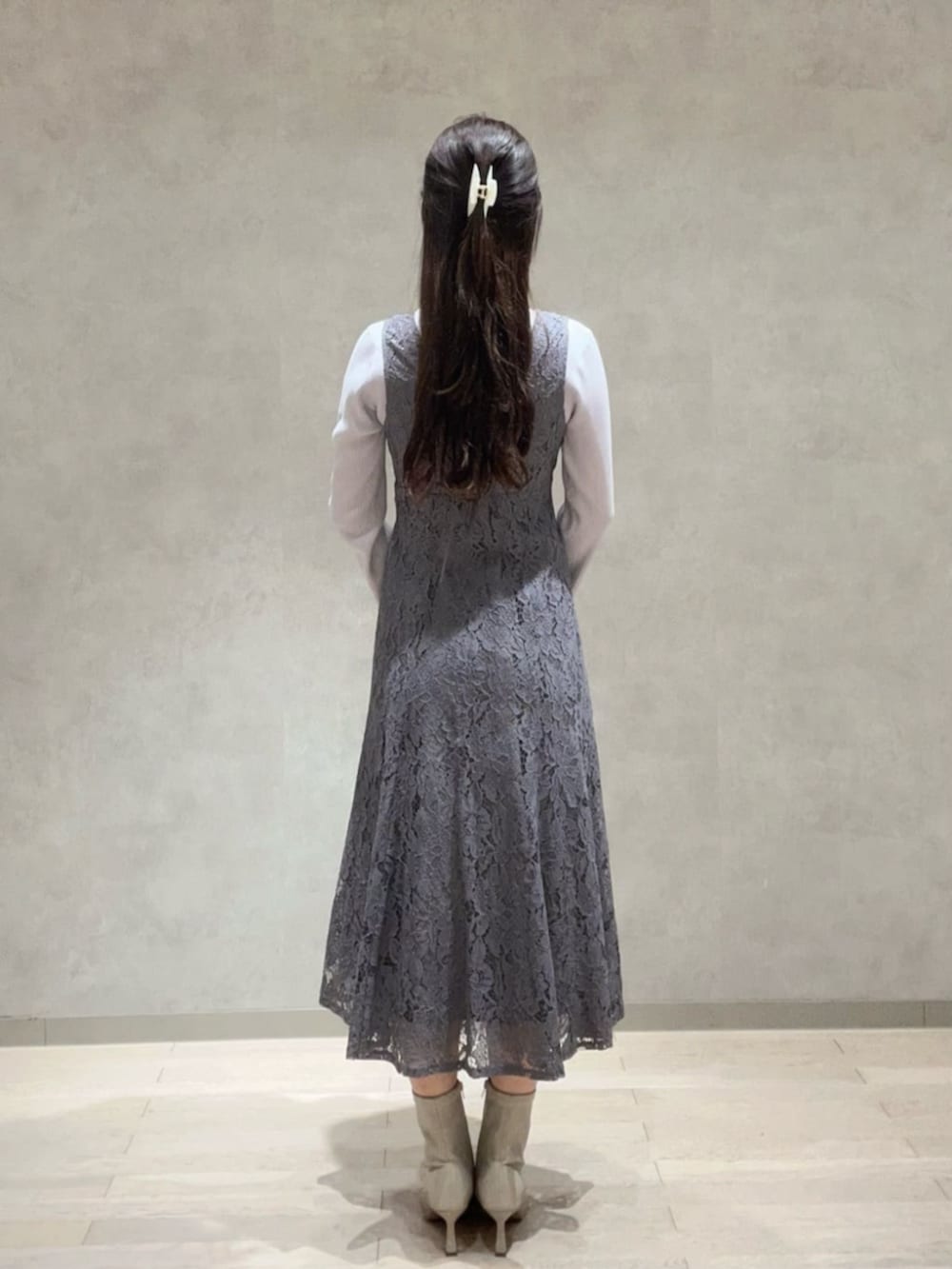 ベージュ系のショルダーバッグ、グレー系のニット/セーター、グレー系のワンピースを着用したレディースの冬コーディネートの3枚目の写真