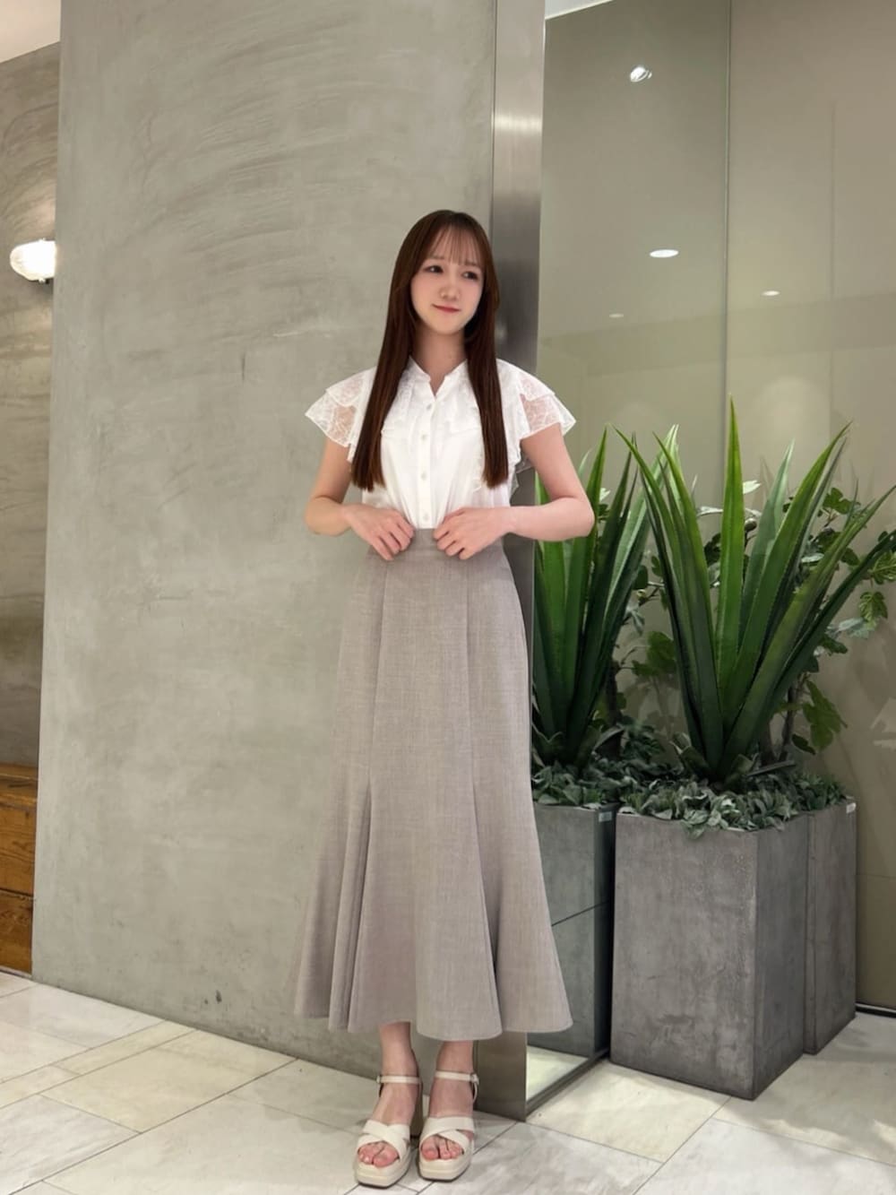 ブラウン系のスカート、ホワイト系のシャツ/ブラウスを着用したレディースの夏コーディネートの3枚目の写真