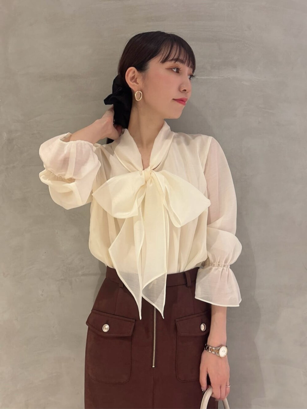 ブラック系のパンプス、ホワイト系のショルダーバッグ、ホワイト系のシャツ/ブラウスを着用したレディースの秋コーディネートの3枚目の写真