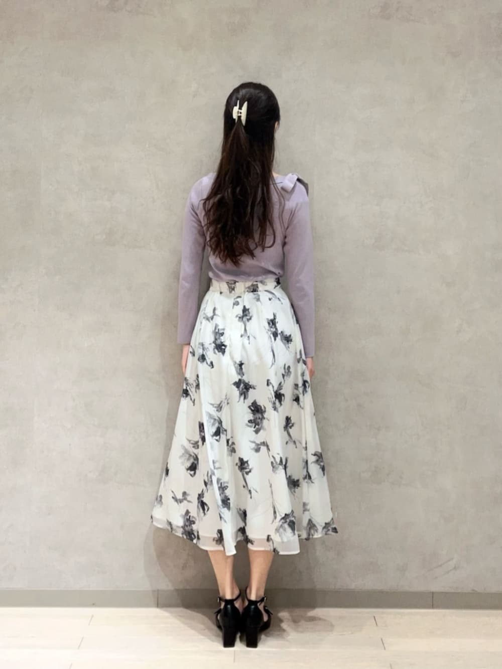 パープル系のニット/セーター、グレー系のスカート、ブラック系のパンプスを着用したレディースの冬コーディネートの3枚目の写真