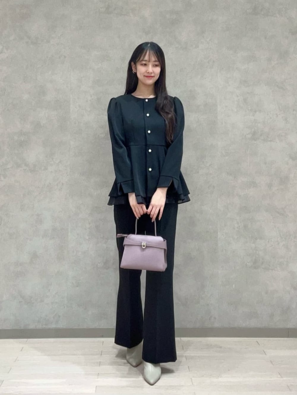 パープル系のトートバッグ、ブラック系のセットアップ、ブラック系のその他パンツを着用したレディースの冬コーディネートの3枚目の写真