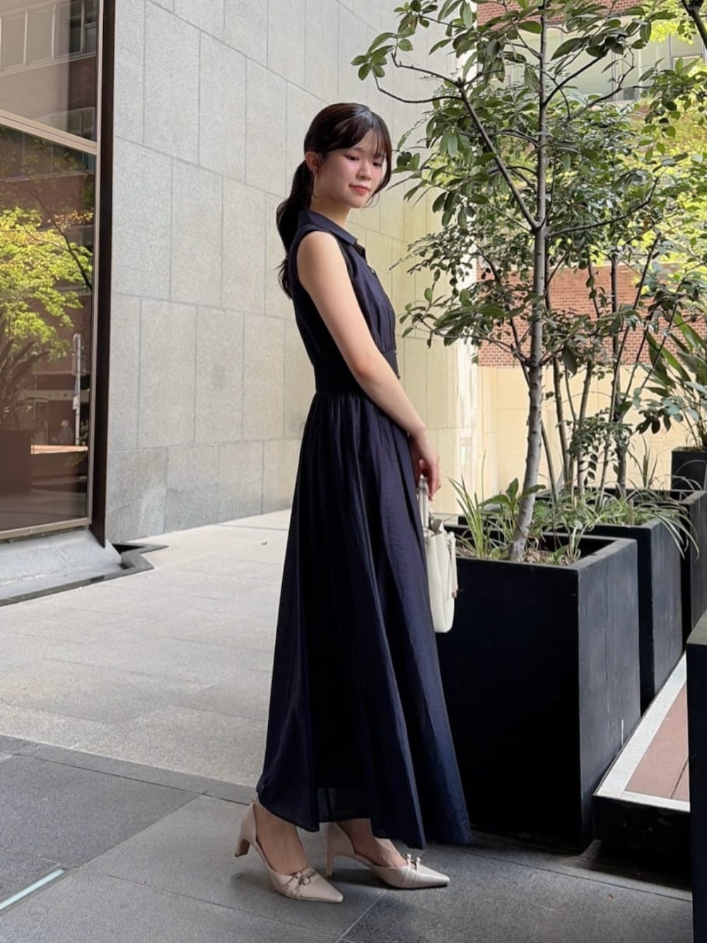 ベージュ系のパンプス、ホワイト系のショルダーバッグ、ブルー系のワンピースを着用したレディースの夏コーディネートの2枚目の写真
