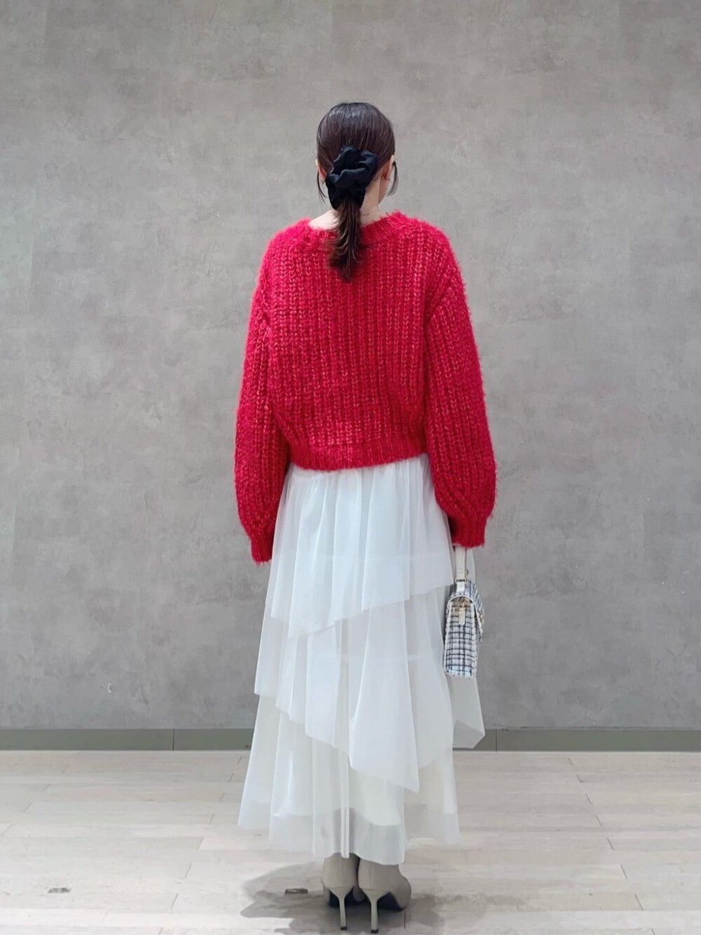 ホワイト系のショルダーバッグ、レッド系のニット/セーター、ホワイト系のスカートを着用したレディースの秋コーディネートの3枚目の写真
