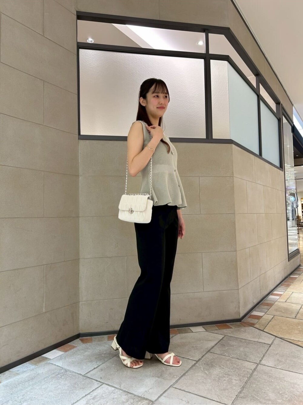 ホワイト系のショルダーバッグ、グリーン系のニット/セーター、ブラック系のその他パンツを着用したレディースの夏コーディネートの2枚目の写真