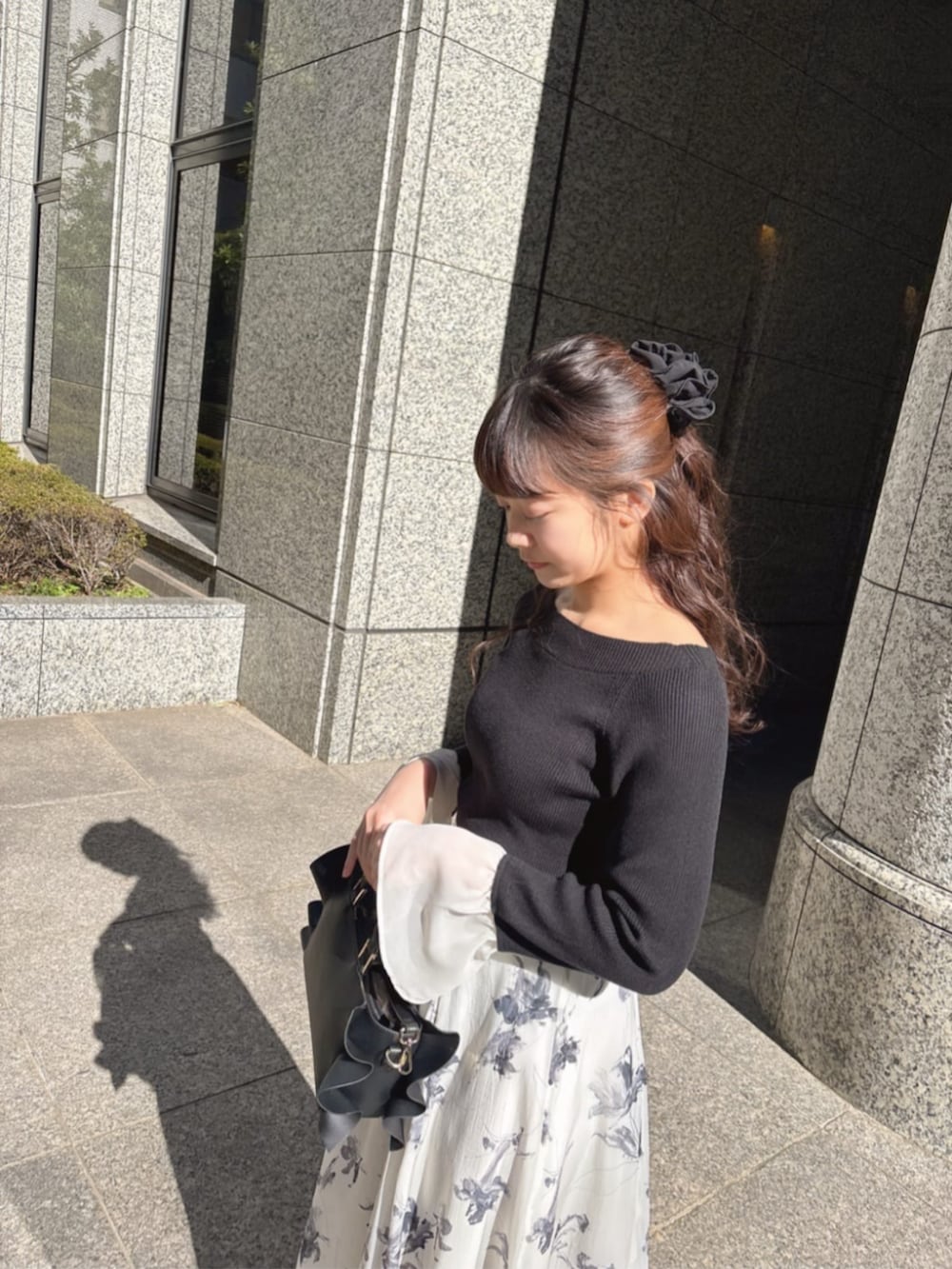 グレー系のスカート、ブラック系のニット/セーターを着用したレディースの冬コーディネートの3枚目の写真