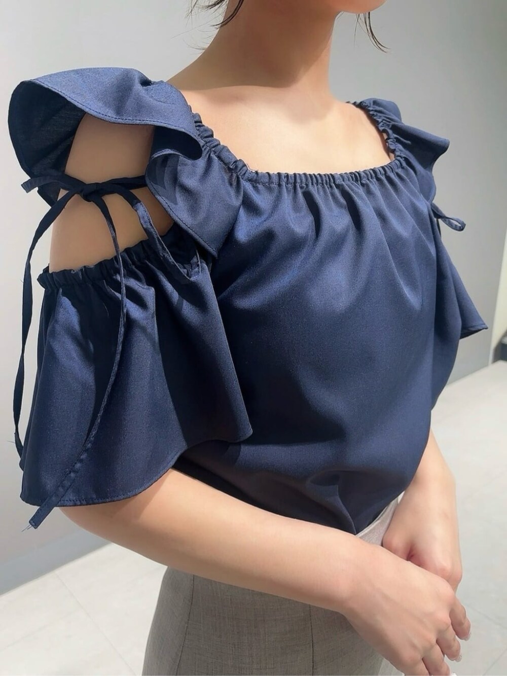 ブラウン系のスカート、ブラック系のパンプス、ブルー系のシャツ/ブラウスを着用したレディースの夏コーディネートの3枚目の写真