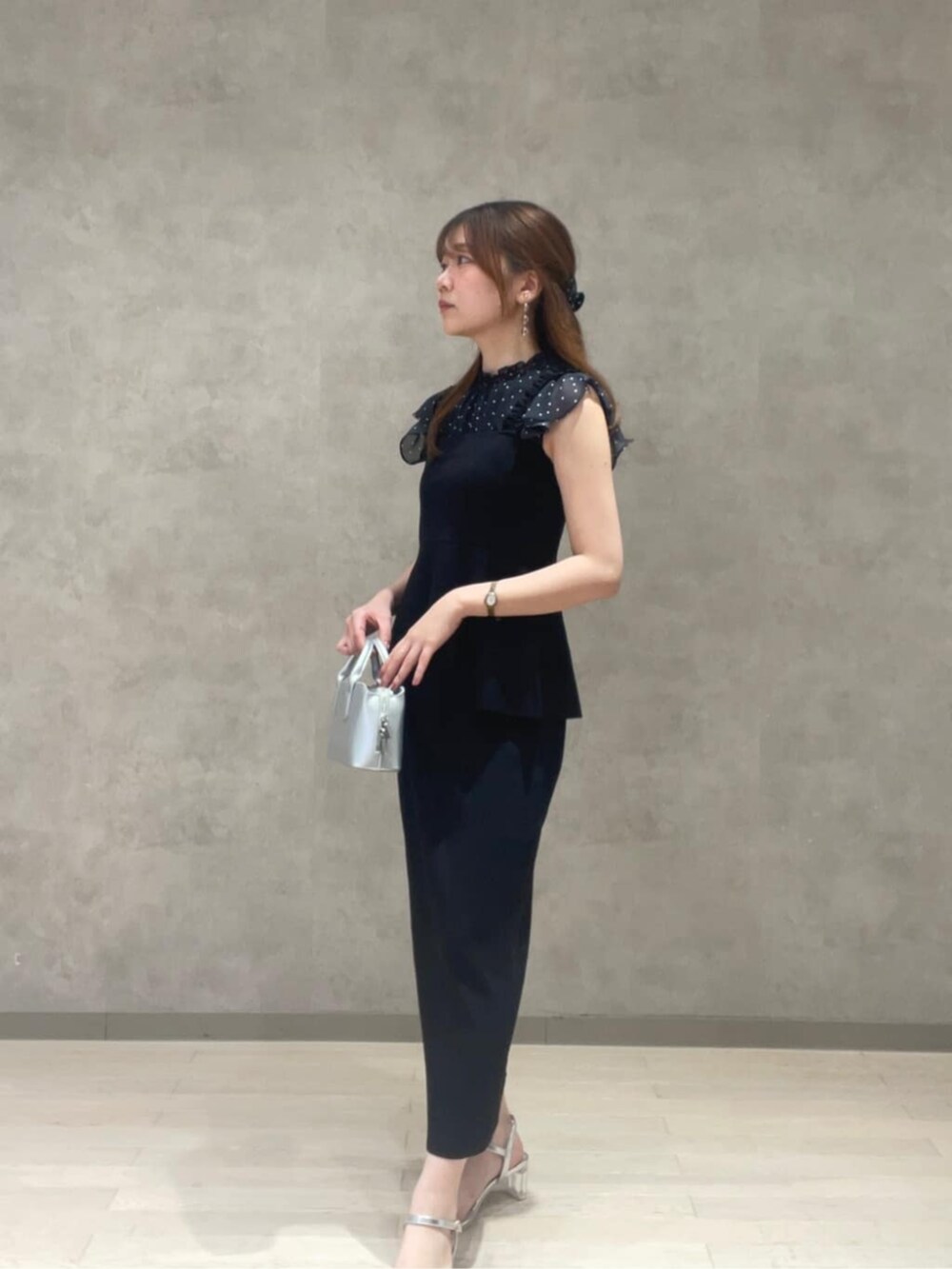 シルバー系のトートバッグ、ブラック系のシャツ/ブラウス、ブラック系のワンピースを着用したレディースの夏コーディネートの2枚目の写真