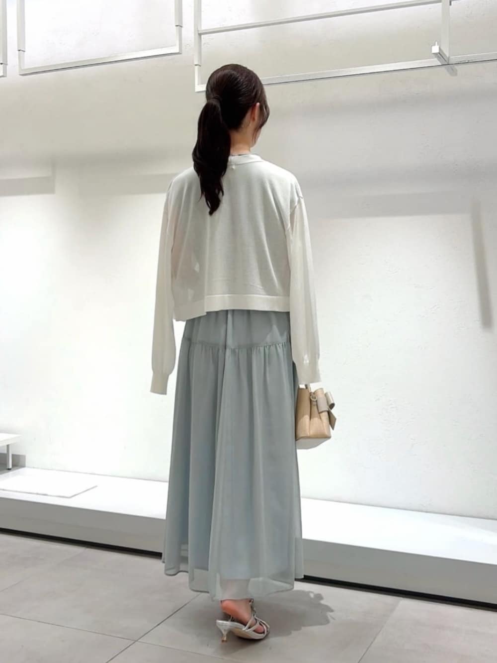 シルバー系のパンプス、ホワイト系のショルダーバッグ、ホワイト系のカーディガン/ボレロを着用したレディースの夏コーディネートの5枚目の写真