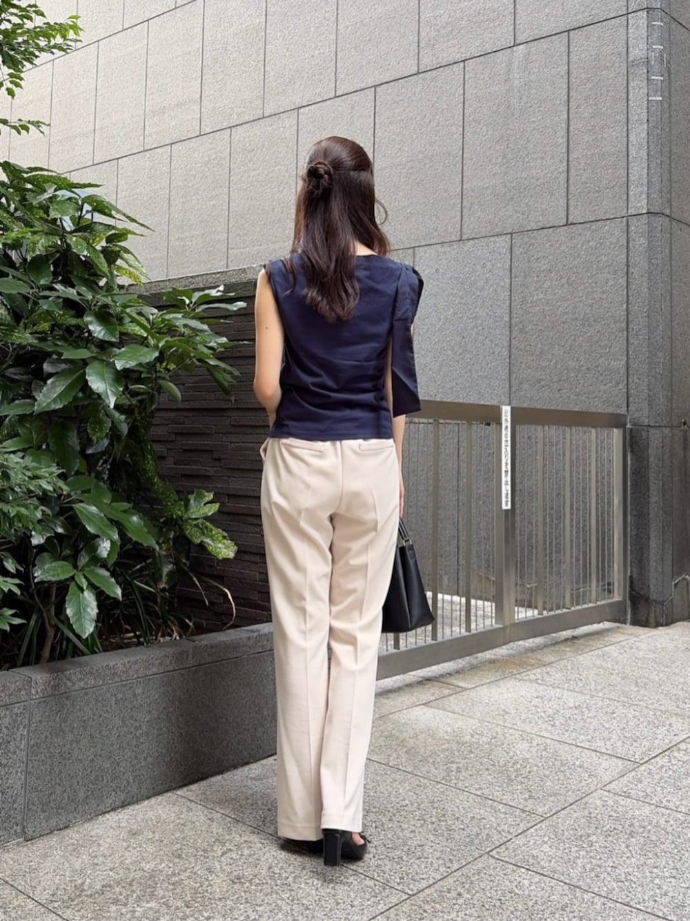 ブラック系のパンプス、ブラック系のショルダーバッグ、ブルー系のTシャツ/カットソーを着用したレディースの夏コーディネートの3枚目の写真
