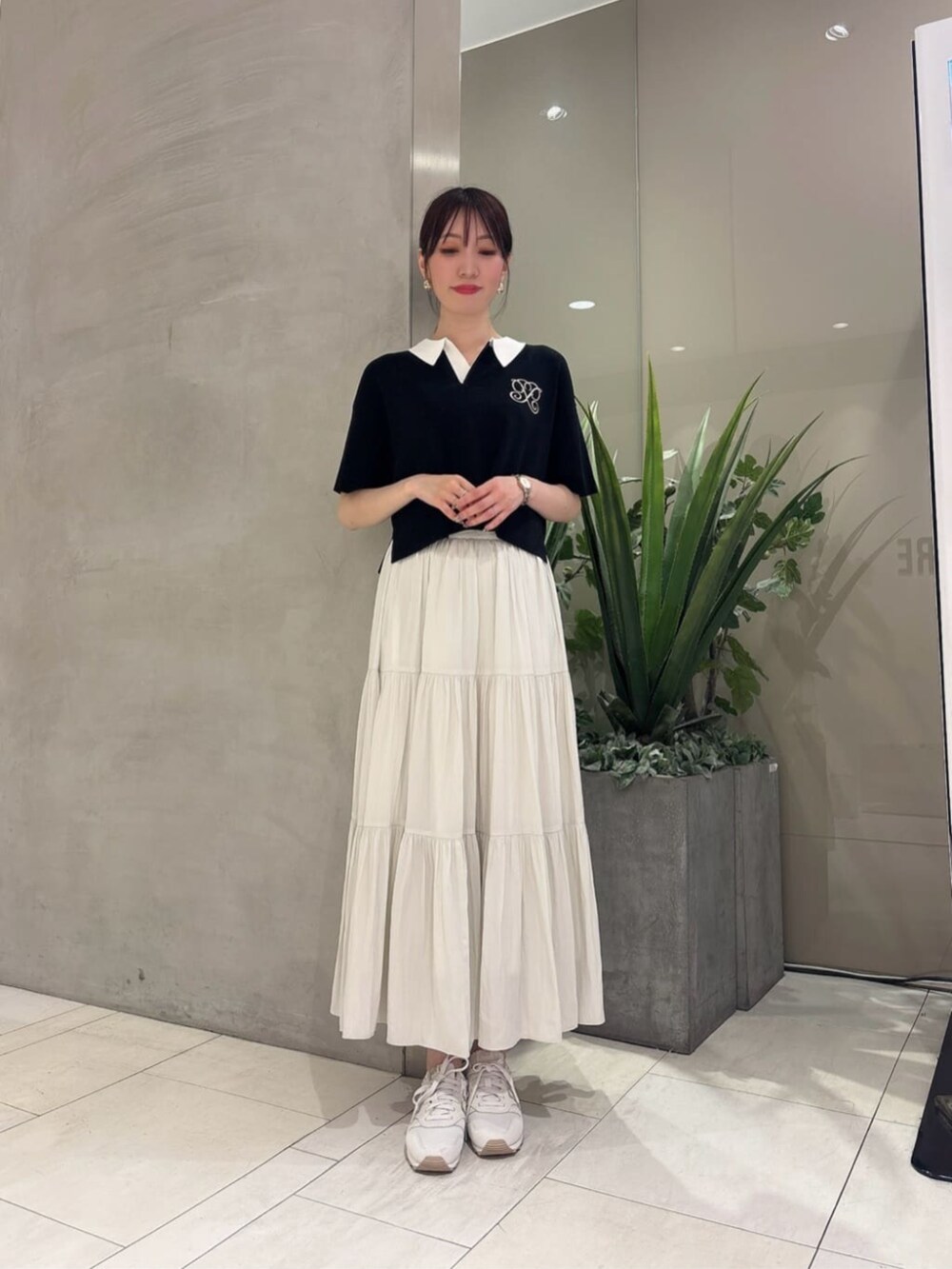 ブラック系のニット/セーター、ホワイト系のスカートを着用したレディースの夏コーディネートの3枚目の写真