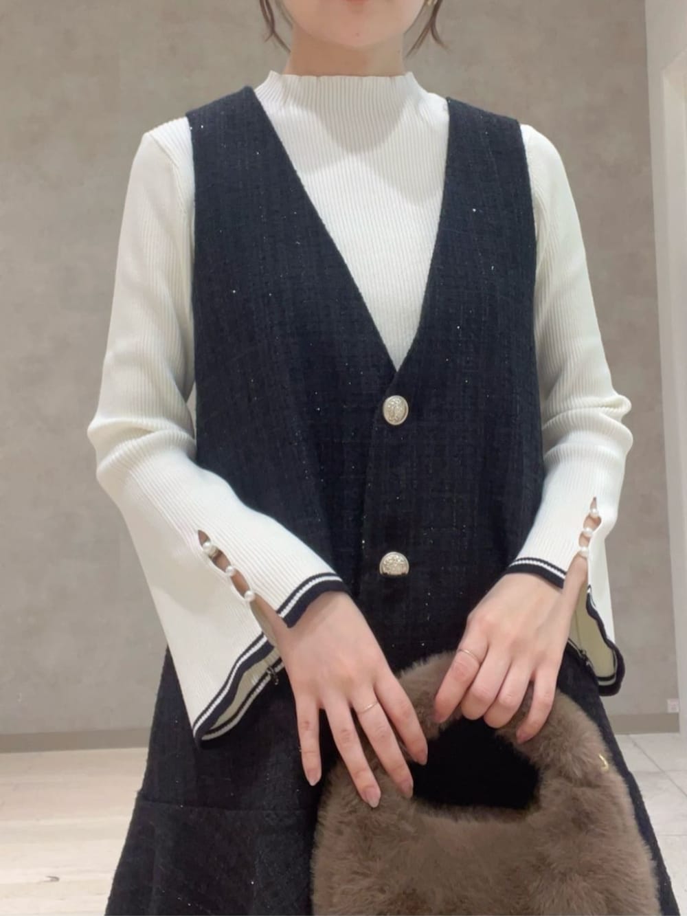 ホワイト系のニット/セーター、ブラック系のワンピース、ブラウン系のハンドバッグを着用したレディースの秋コーディネートの3枚目の写真