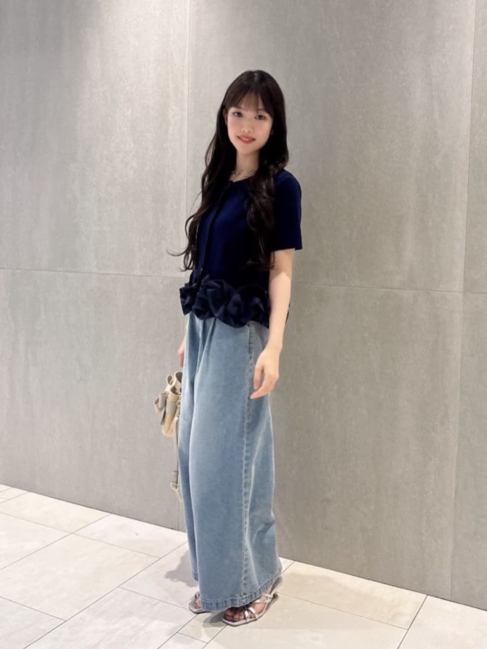 シルバー系のパンプス、ブルー系のその他パンツ、ホワイト系のショルダーバッグを着用したレディースの夏コーディネートの2枚目の写真