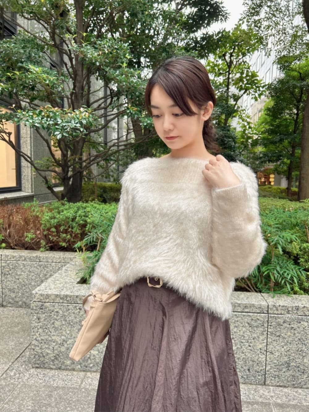 ホワイト系のニット/セーター、ブラウン系のスカート、ベージュ系のショルダーバッグを着用したレディースの秋コーディネートの2枚目の写真