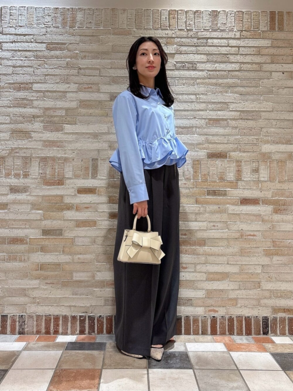 ホワイト系のショルダーバッグ、ブルー系のシャツ/ブラウス、グレー系のその他パンツを着用したレディースの春コーディネートの2枚目の写真
