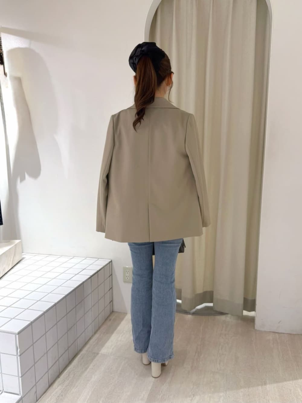 ブルー系のデニムパンツ、ホワイト系のシャツ/ブラウス、ブラウン系のショルダーバッグを着用したレディースの秋コーディネートの4枚目の写真