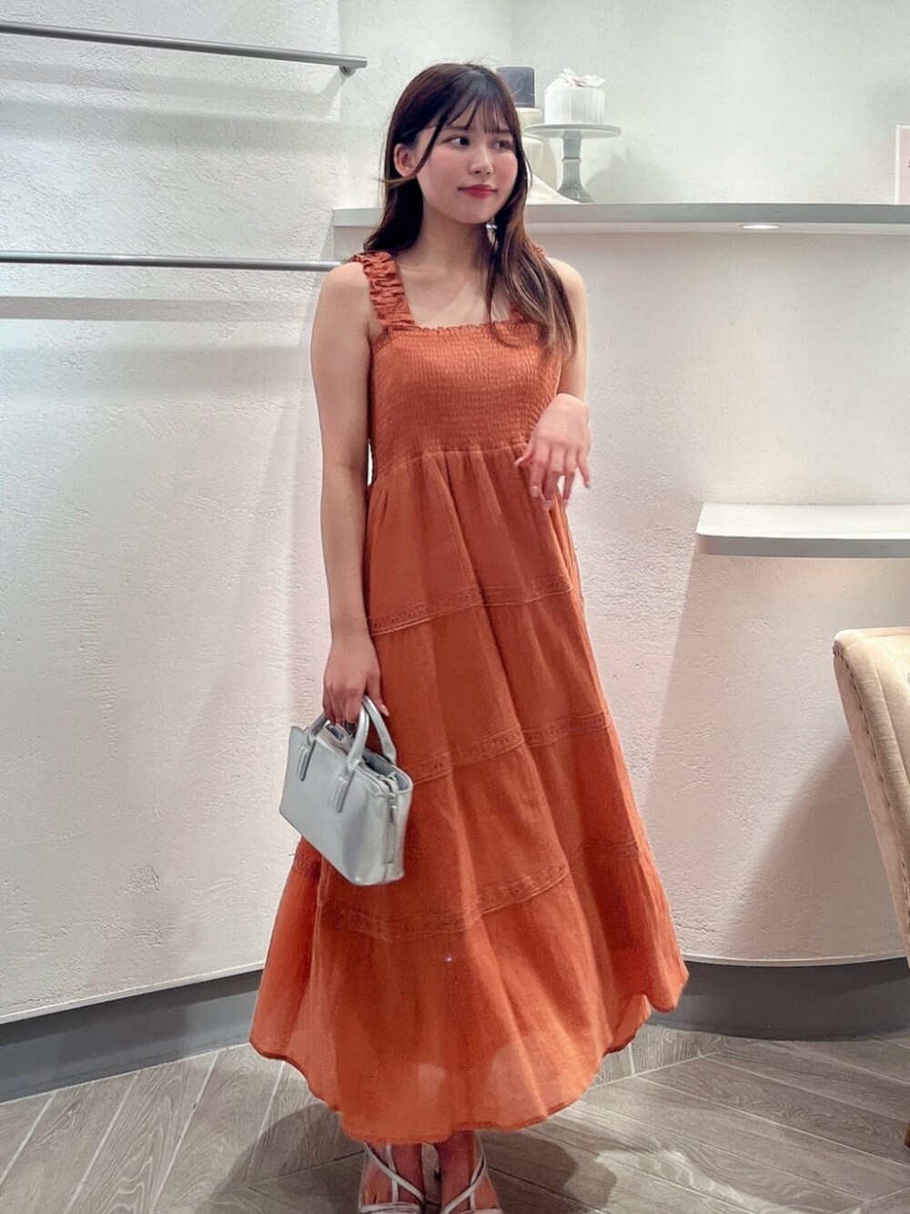 シルバー系のパンプス、ホワイト系のカーディガン/ボレロ、シルバー系のトートバッグを着用したレディースの夏コーディネートの3枚目の写真