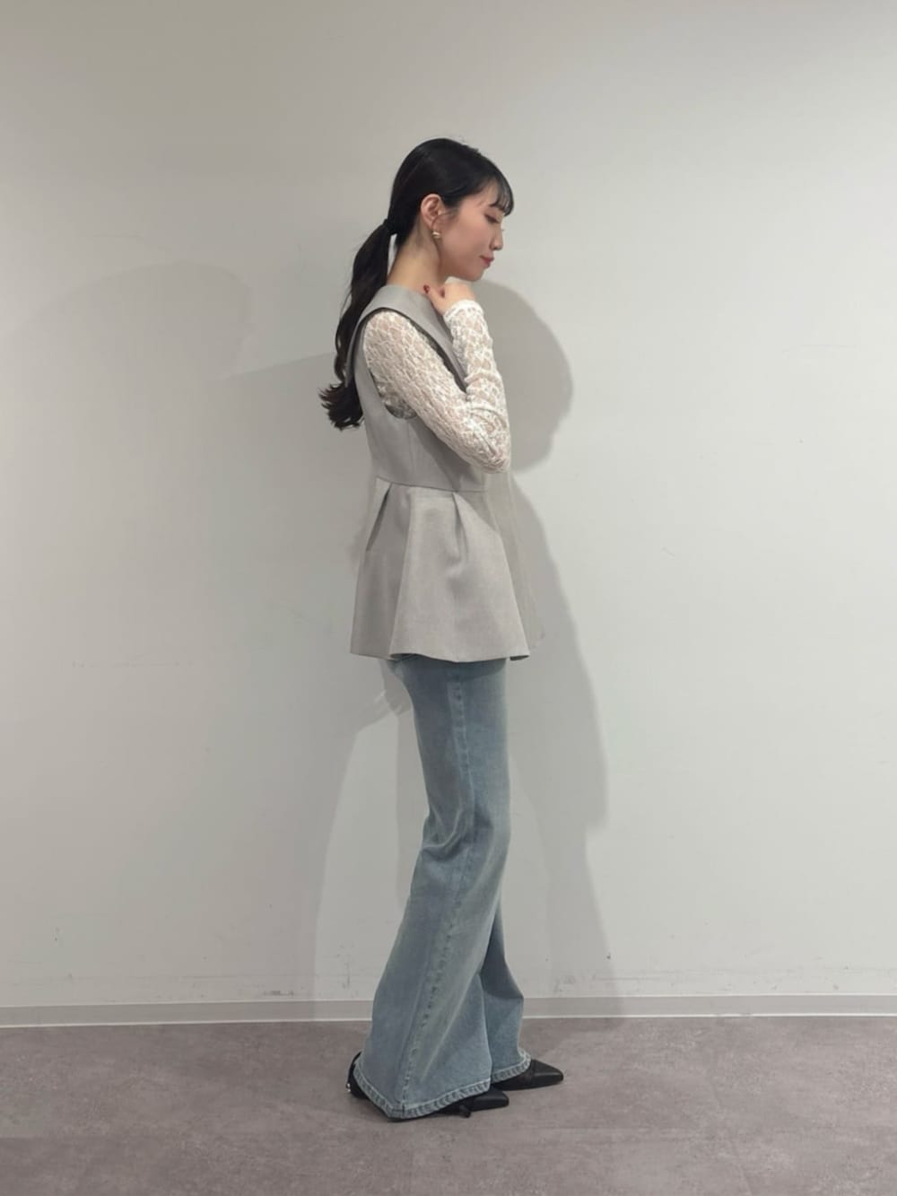 ホワイト系のTシャツ/カットソー、グレー系のベスト、ブルー系のデニムパンツを着用したレディースの春コーディネートの2枚目の写真