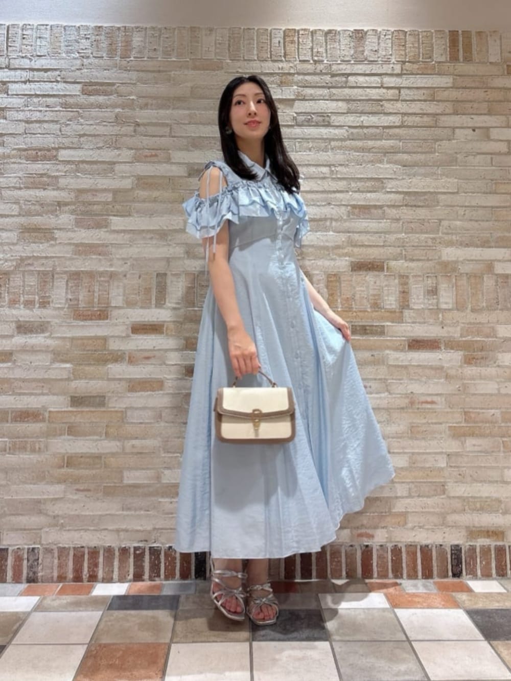 グレー系のショルダーバッグ、シルバー系のパンプス、ブルー系のワンピースを着用したレディースの夏コーディネートの2枚目の写真