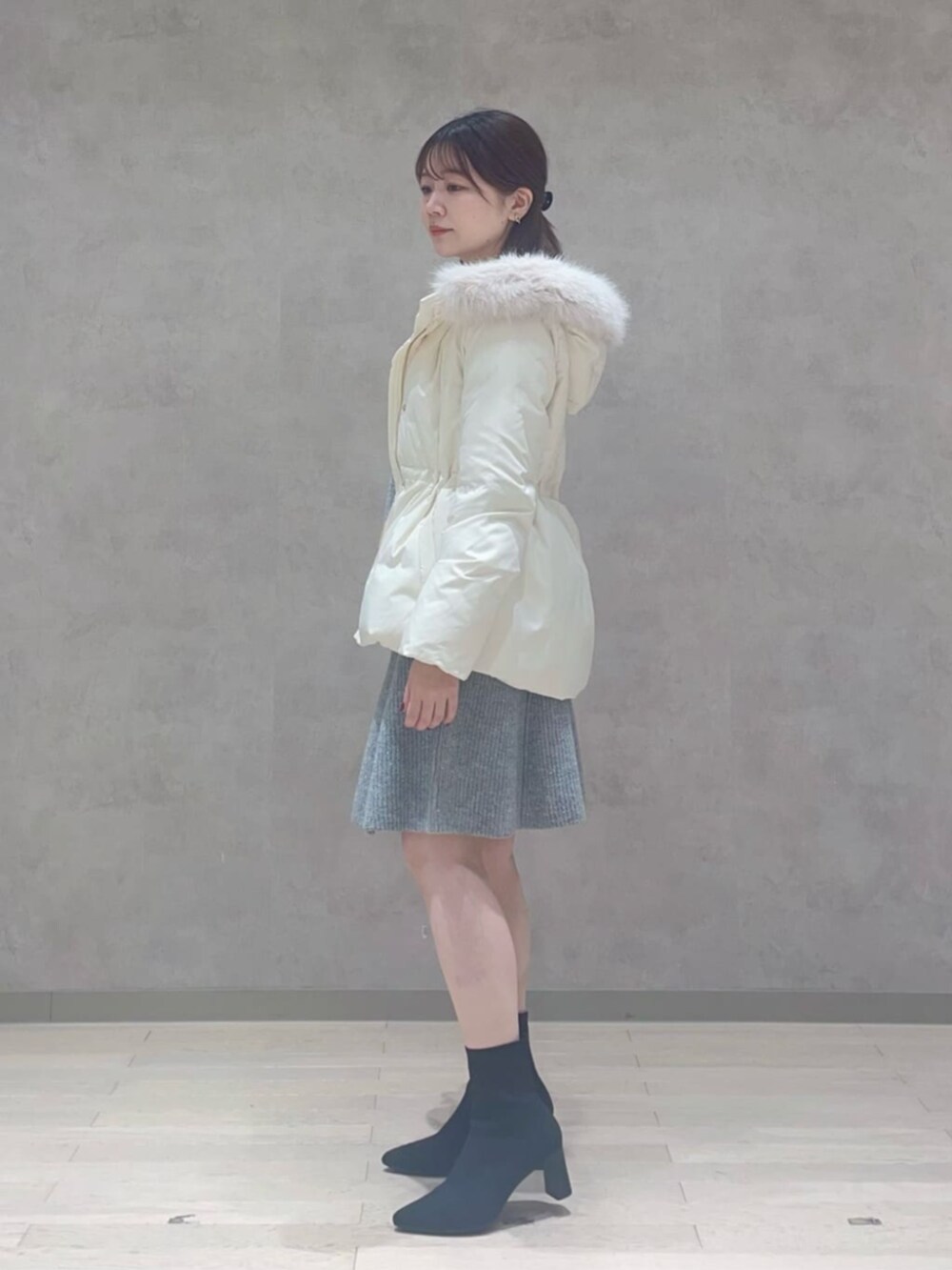 ホワイト系のダウンジャケット/コート、グレー系のワンピースを着用したレディースの冬コーディネートの2枚目の写真