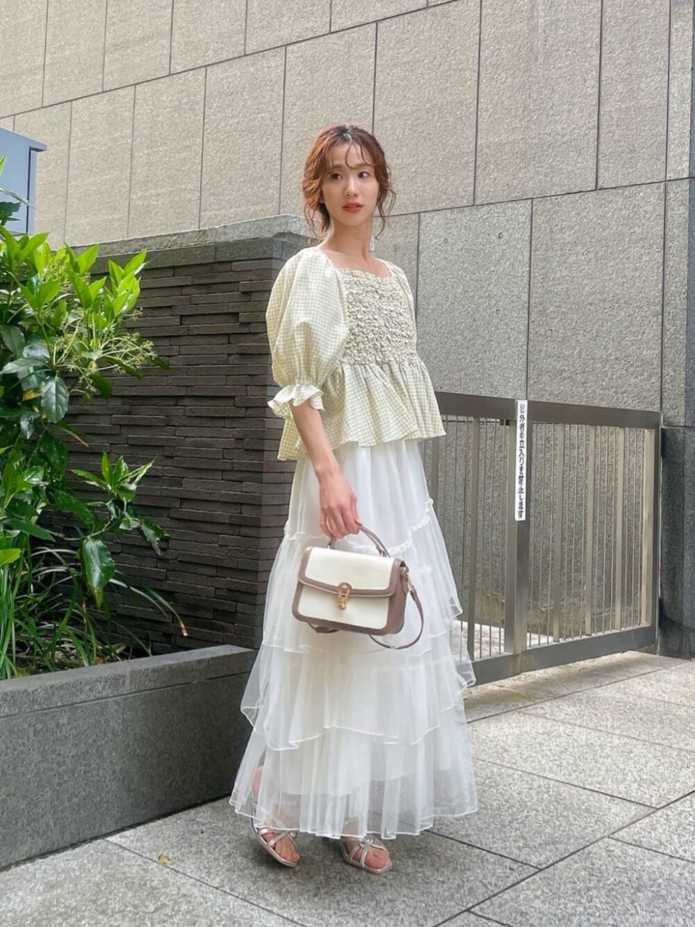 シルバー系のパンプス、グリーン系のシャツ/ブラウス、ホワイト系のスカートを着用したレディースの春コーディネートの2枚目の写真